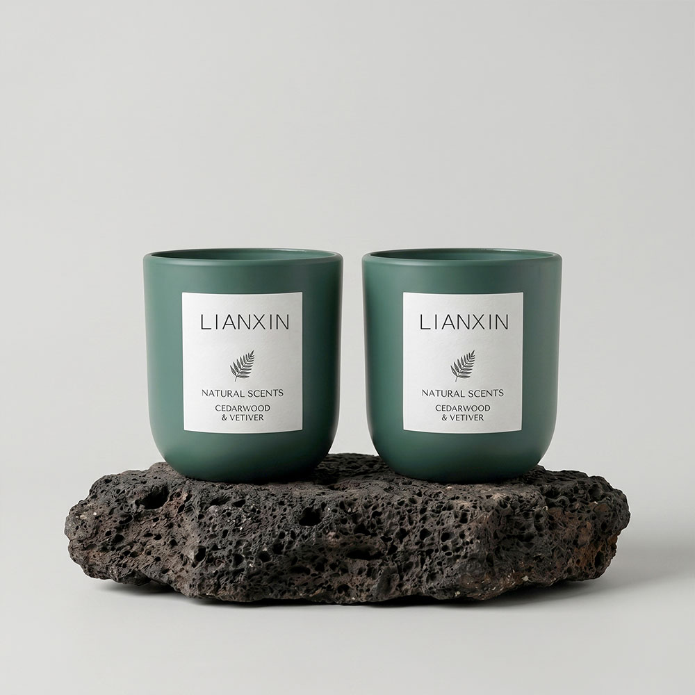 Two forest green matte candle jars on volcanic stone base