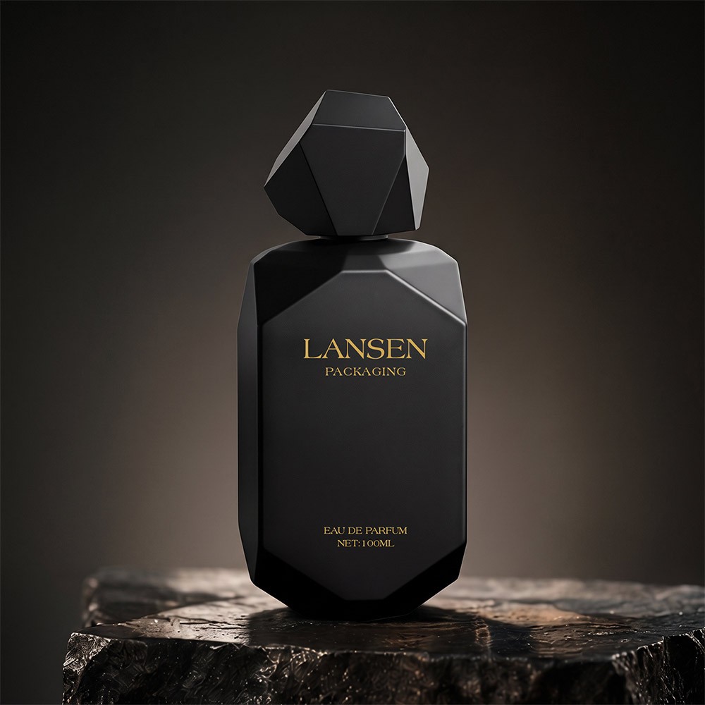100ml matte black irregular glass perfume bottle with a faceted polyhedron cap and gold lettering on a dark stone plinth