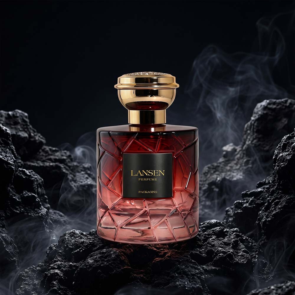 100ml crystal cut perfume bottle with a red gradient body standing among black rock against a dark background