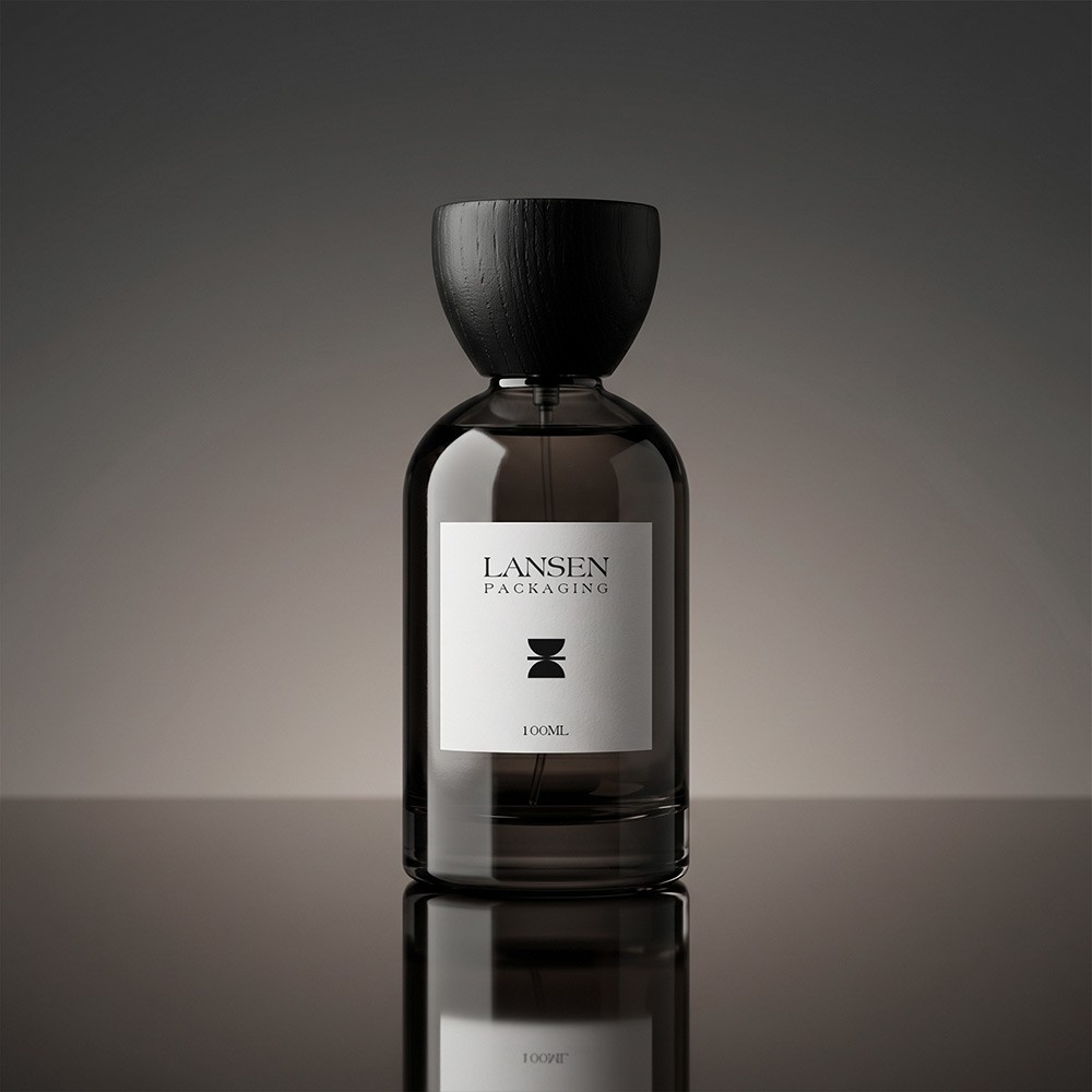 100ml translucent grey glass perfume bottle with a black flared wooden cap and a white wrap label