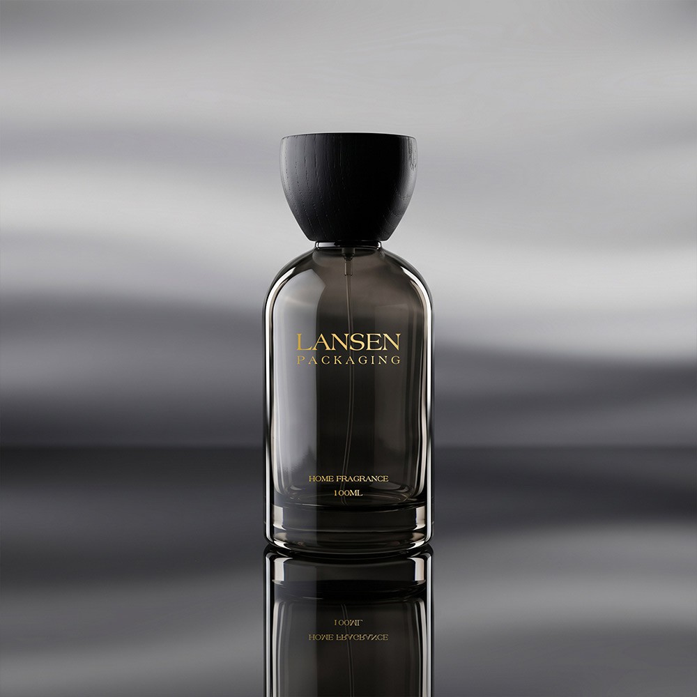 grey glass perfume bottle with a gold lettered brand mark printed straight onto the glass and a black flared wooden cap