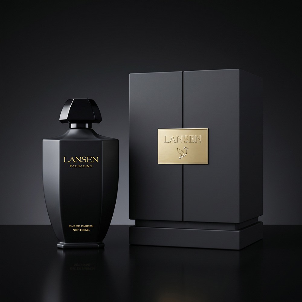 100ml tapered faceted glass perfume bottle in matt black beside a rigid gift box with a gold nameplate