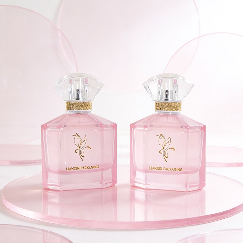 two 110ml chamfered corner perfume bottles in translucent pink standing on pink acrylic discs