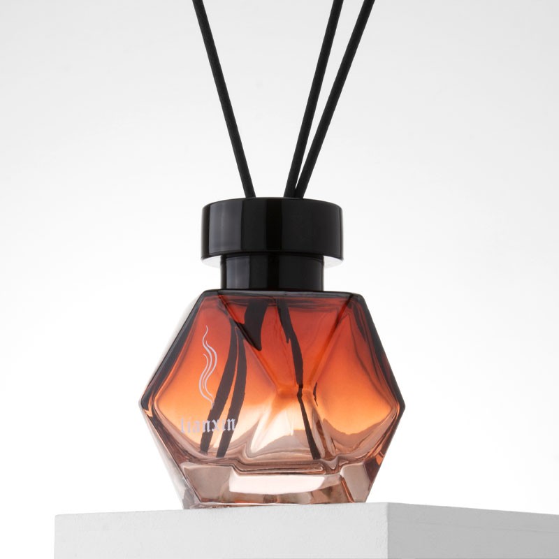 200ml irregular faceted amber glass reed diffuser bottle close up on a white block