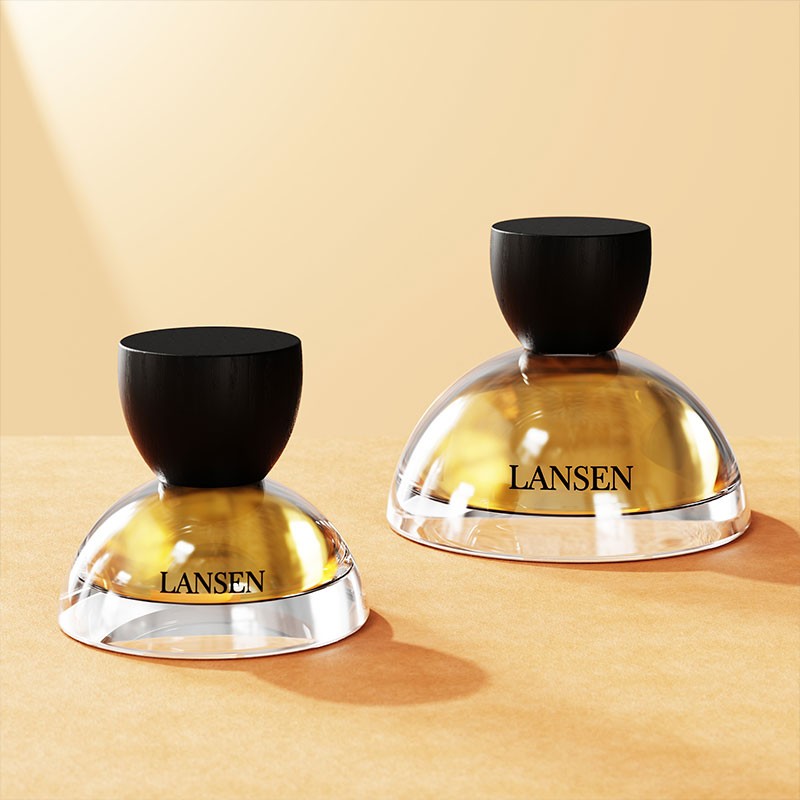 30ml and 100ml dome shaped perfume bottles side by side with black wood grain bowl caps and gold fragrance liquid