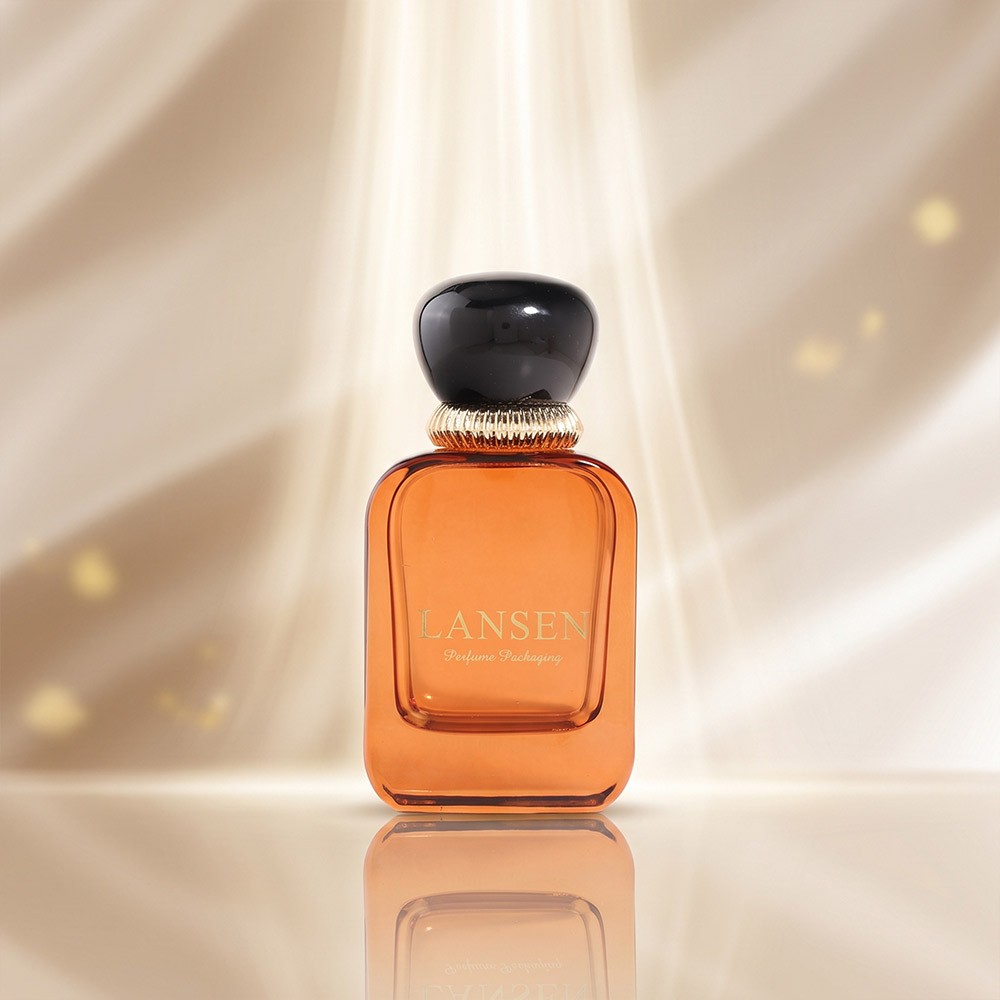 50ml amber flat square glass perfume bottle with a black dome cap on a ridged gold collar
