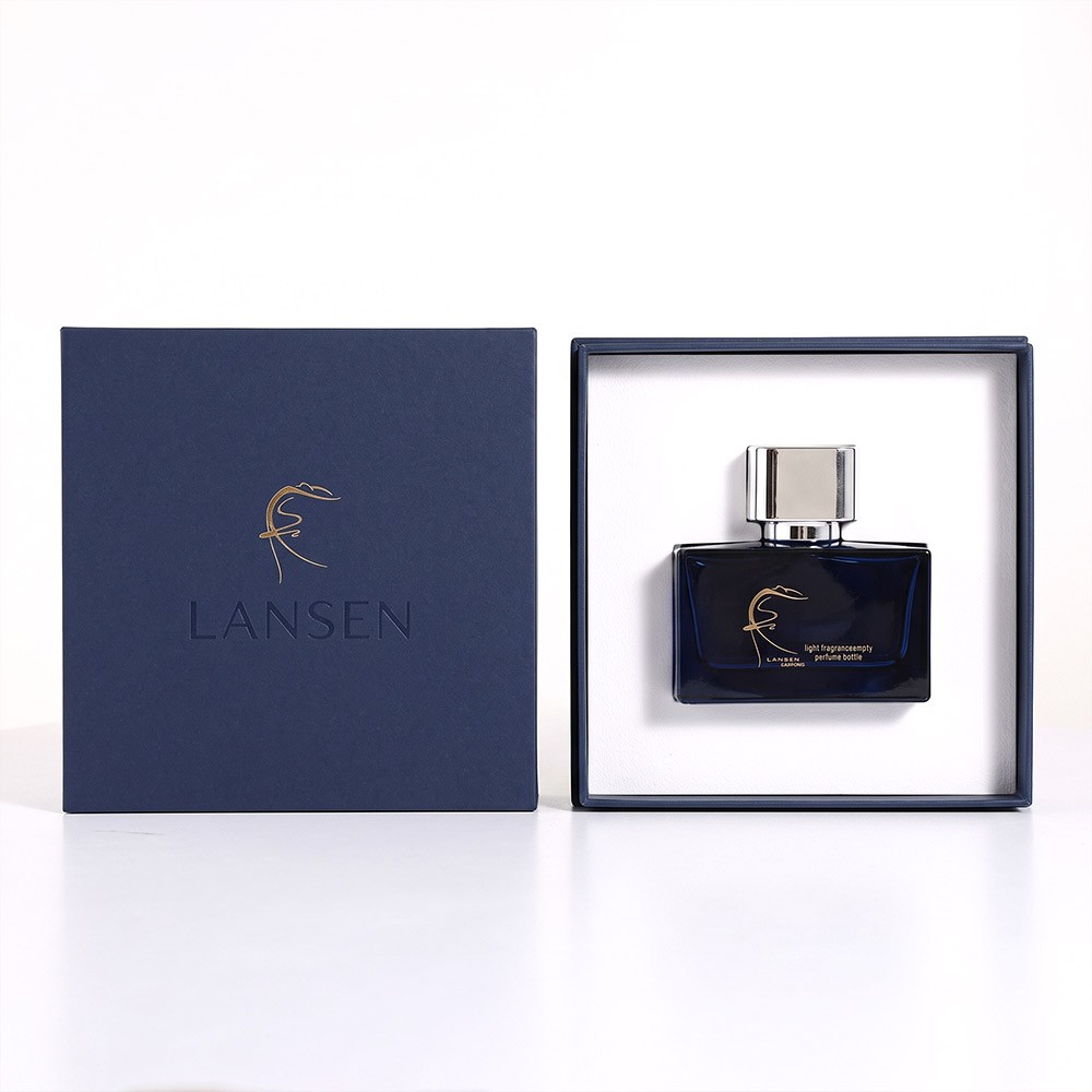 50ml navy blue cologne bottle held in the white insert of an open rigid navy gift box beside its flat lid