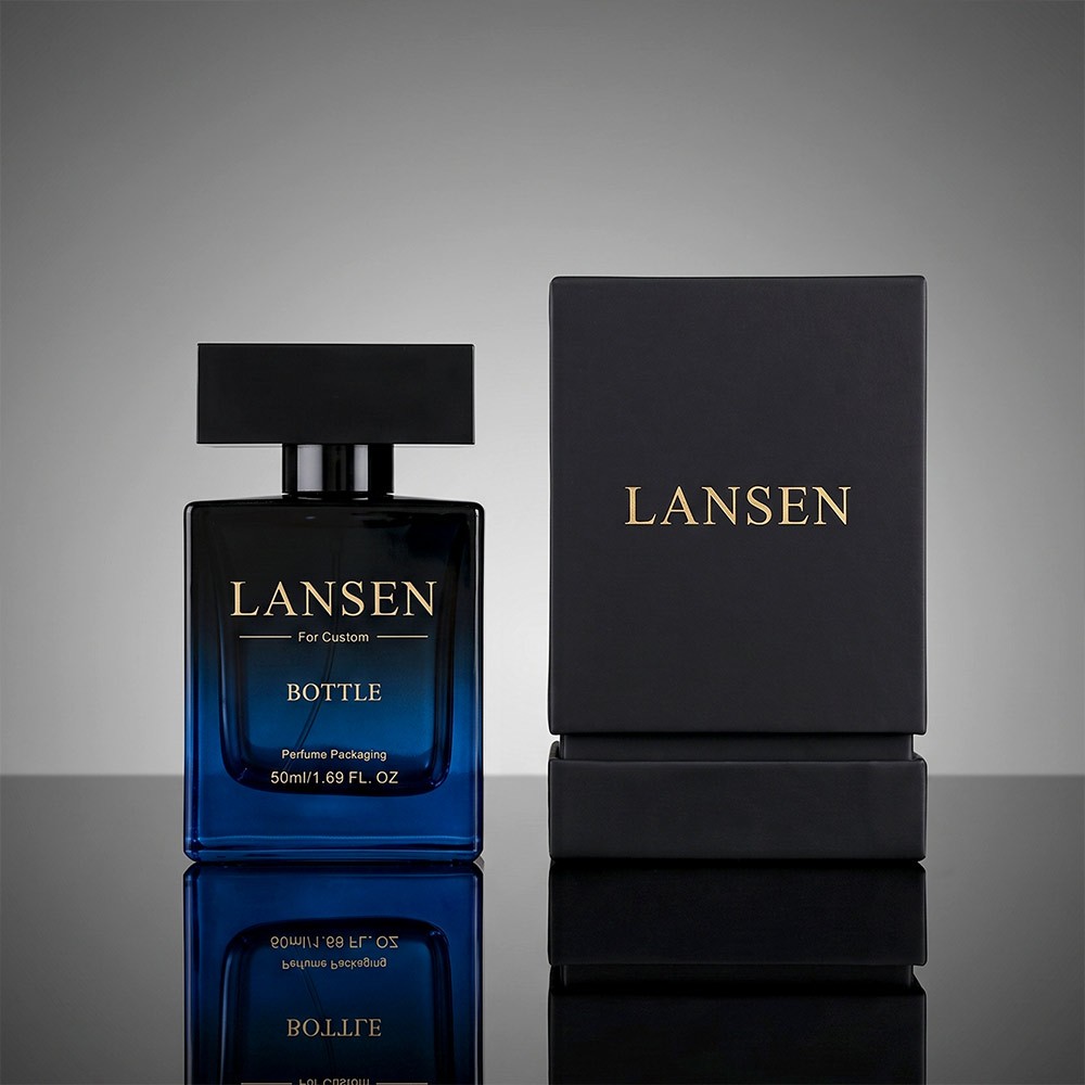 50ml black rectangular cologne bottle with a two tone block cap standing on a marble plinth against a dark wall