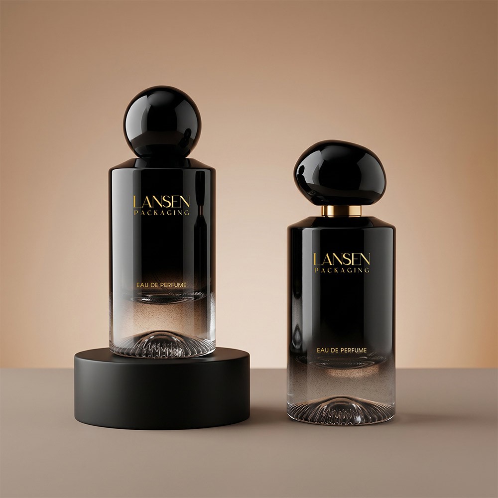 two black gradient glass perfume bottles shown with a full spherical cap and a flattened spherical cap on a gold collar