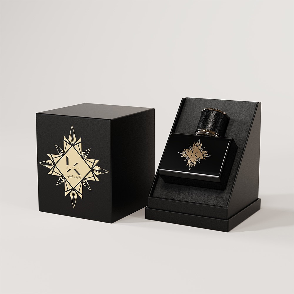 black rigid gift box with a gold star medallion beside a black square perfume bottle set in a display insert