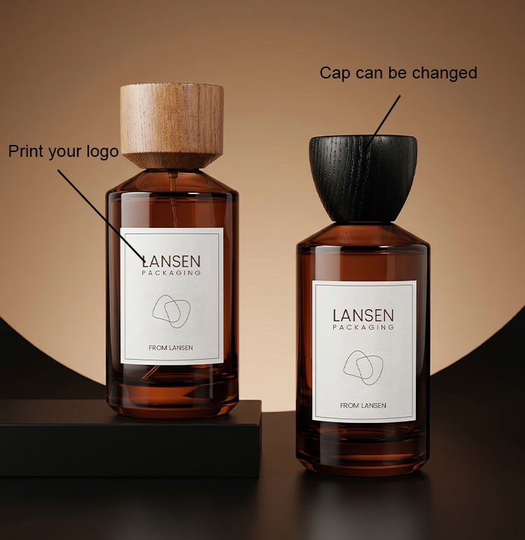 two custom amber cylinder perfume bottles showing a changeable black wood cap and a printed brand logo