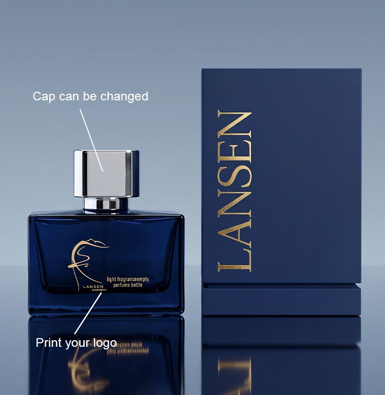 custom navy blue cologne bottle shown with a changeable cap and a printed brand logo beside a rigid navy gift box