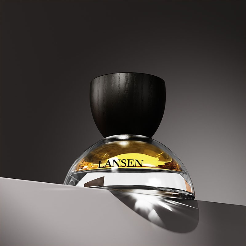 dome shaped glass perfume bottle with a black wood grain cap and gold liquid lit against a dark gradient background