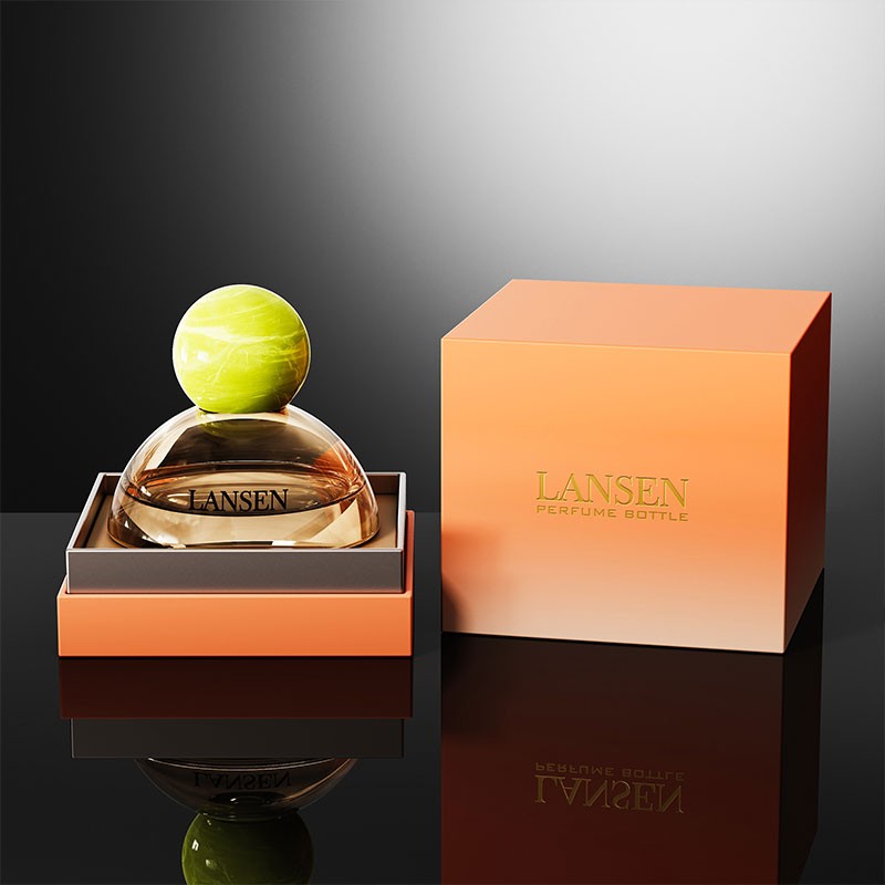 dome shaped perfume bottle with a lime green marbled ball cap and an amber body next to a matching orange gift box